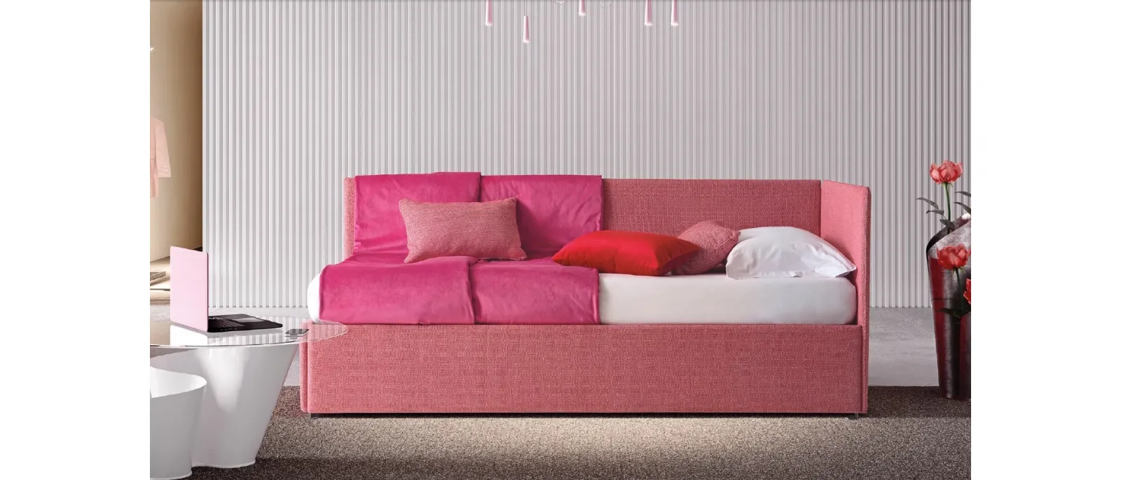Pentas by Le Comfort is a single bed with fabric upholstery and an additional pullout mattress under the bed. The headboard